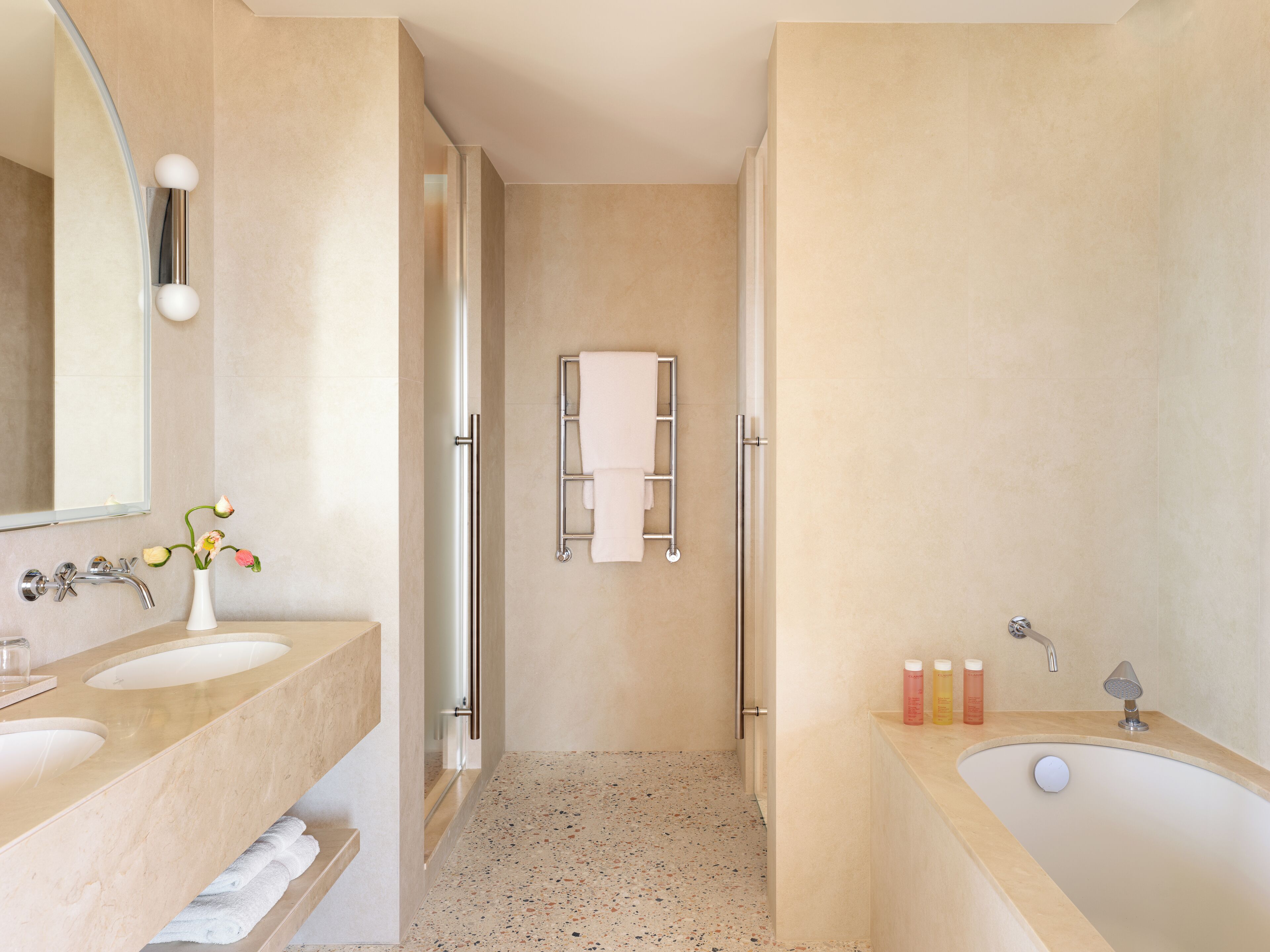 Un bagno moderno con due lavabi, una doccia e un portasciugamani.