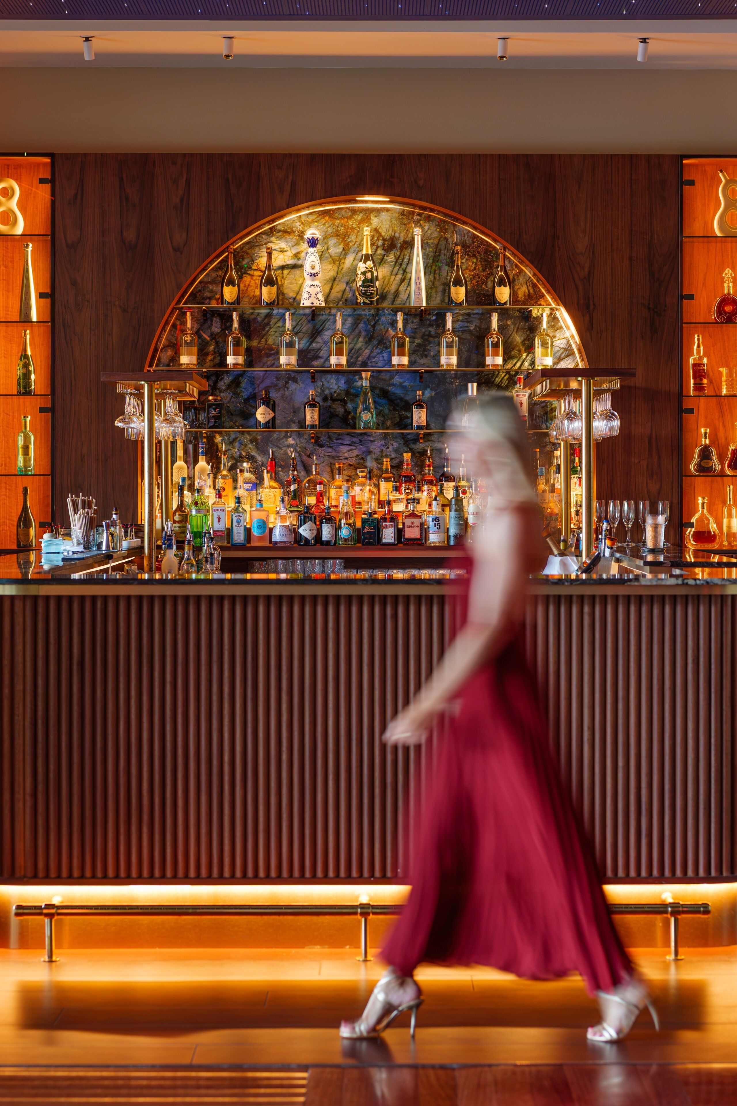 A bar area with a variety of liquor bottles and glasses.