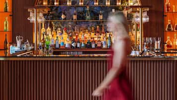 A bar area with a variety of liquor bottles and glasses.