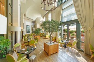 Un espacio interior amplio con diversas opciones de asientos, un jardín interior central y grandes ventanales que aportan luz natural.