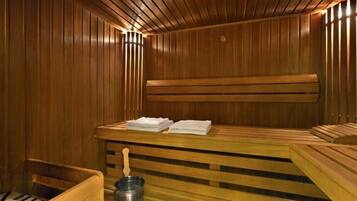 Una sauna con bancos de madera y un banco con toallas.