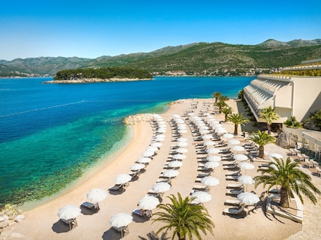 On the beach, sun loungers, beach umbrellas, beach towels. President Hotel, Valamar Collection