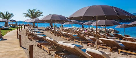 Sulla spiaggia, lettini da mare, ombrelloni, teli da spiaggia