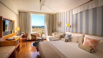 Una habitación de hotel con una cama grande, un escritorio, una silla, un sofá y un televisor.