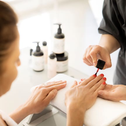 A close-up of a person receiving a manicure.