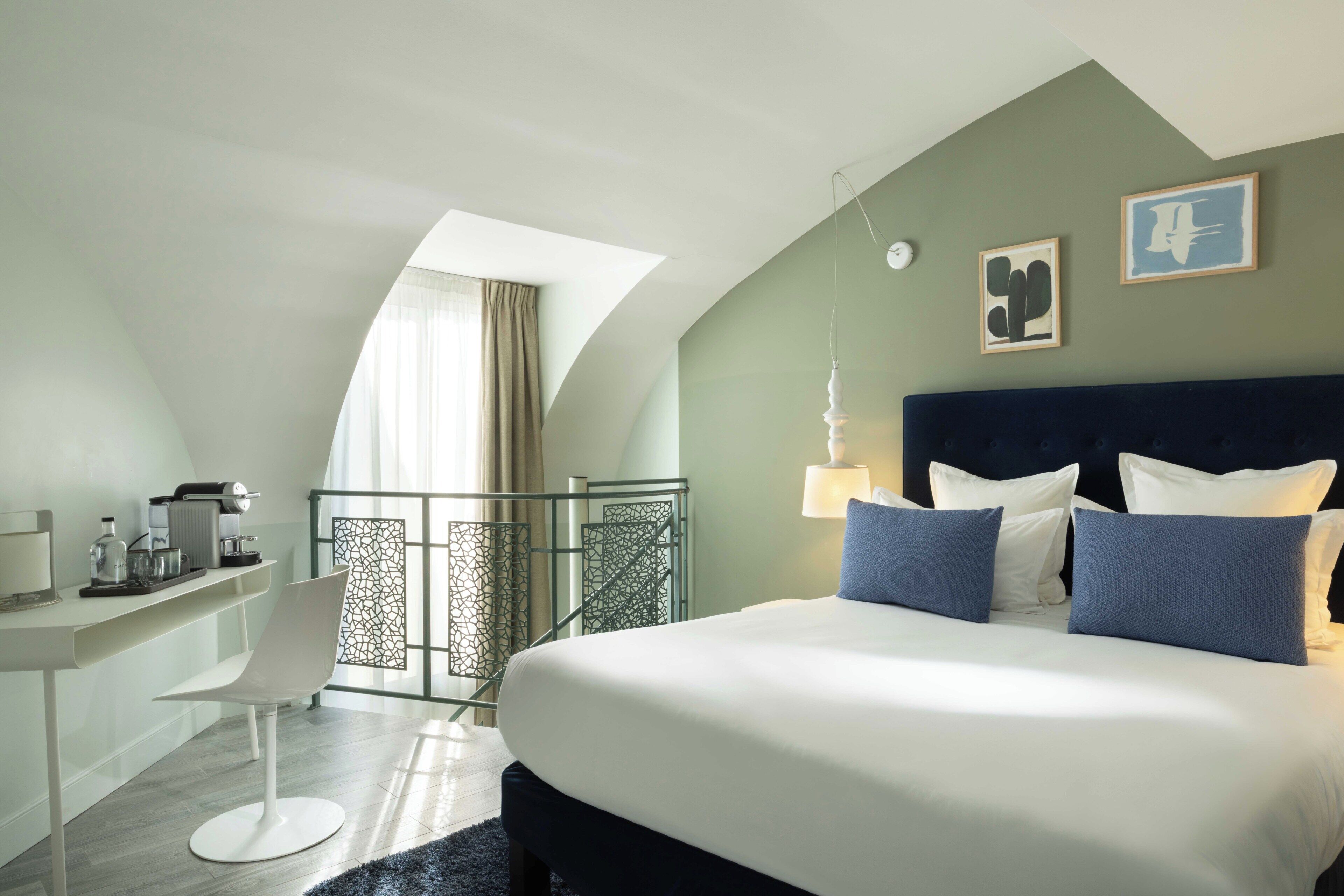 Une chambre d’hôtel moderne avec un grand lit, un bureau et une chaise.