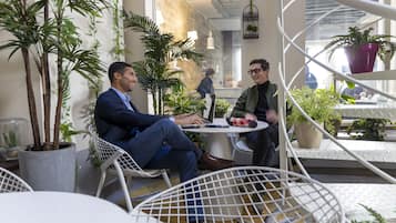 Ein Café mit Außenbereich, Blumentöpfen und modernem Interieur.