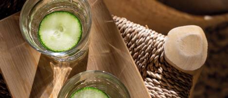 Two glasses of cucumber water on a wooden tray.