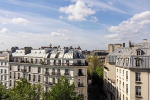 A row of Parisian buildings with classic architecture, featuring multiple stories and balconies. - Hôtel MARAIS HÔme (Paris)