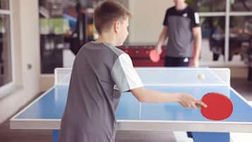 A table tennis table with a net in an indoor setting.