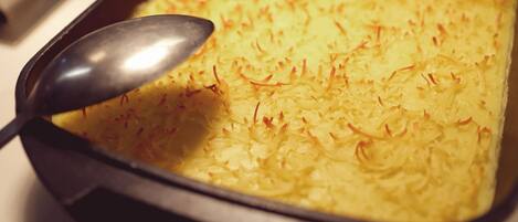 A rectangular baking dish with a golden-brown top layer, likely a baked dish with shredded topping.