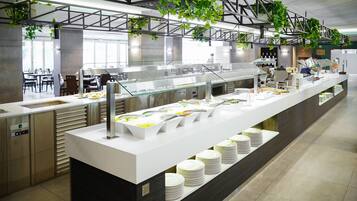 Ein modernes Buffet mit mehreren Speiseausgaben, einer langen Theke und einem klaren, industriellen Design.