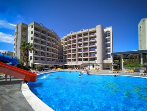 A hotel with a large swimming pool, multiple balconies, and a water slide. - Ohtels Belvedere (Salou)