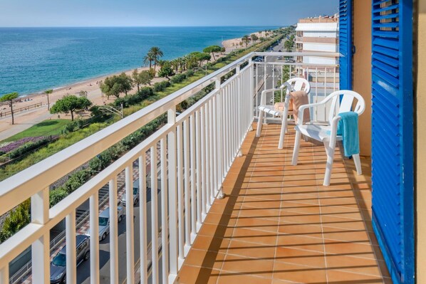 A balcony with a view of the beach and ocean.