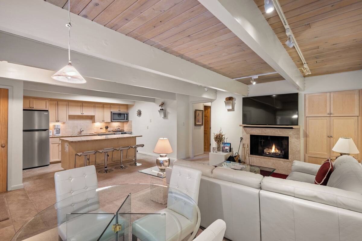 Een moderne keuken met een centraal eiland, barstoelen en een ingebouwde oven.