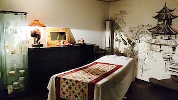 A bedroom with a bed, a dresser, a mirror, and a wall with a mural.
