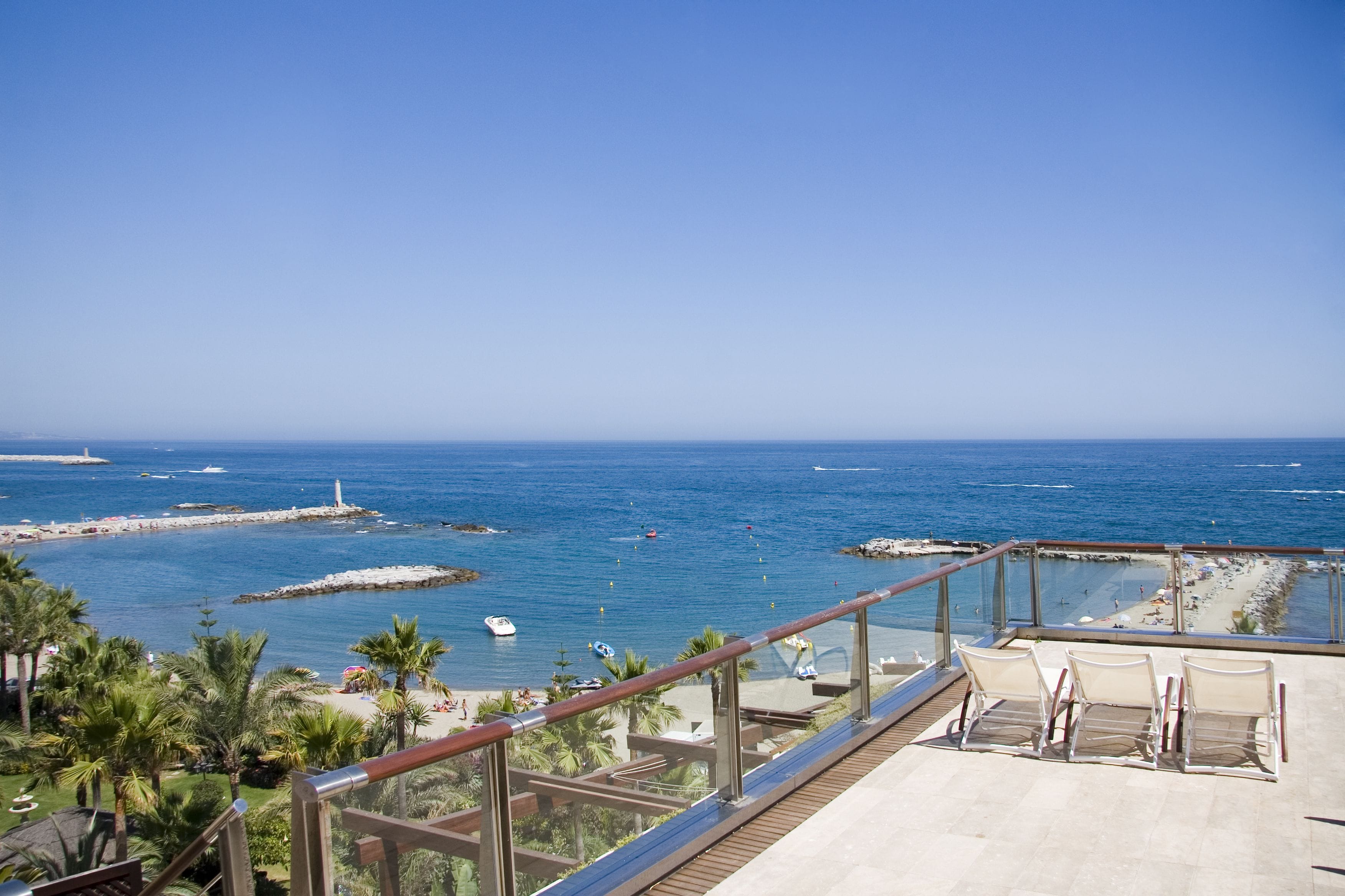 Un balcon avec vue sur la mer, une plage et un phare.