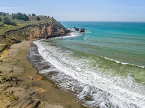 A coastal beach with rocky cliffs and clear blue waters. - Inn at Rockaway San Francisco Pacifica (Pacifica)