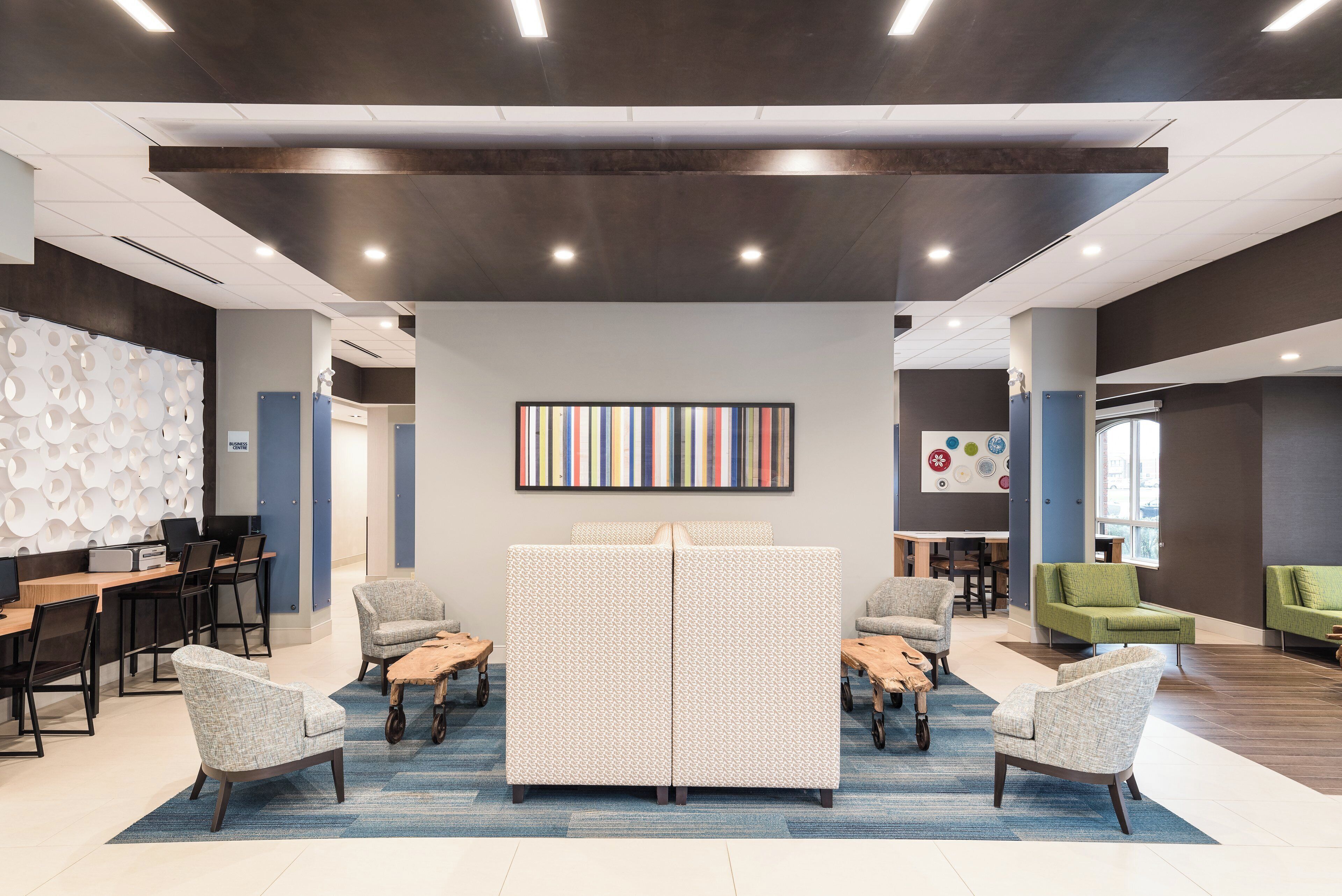 A modern interior with a central seating area, a wall-mounted artwork, and a mix of seating options.