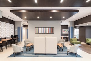 A modern interior with a central seating area, a wall-mounted artwork, and a mix of seating options. - Holiday Inn Express & Suites Milton by IHG (Milton)