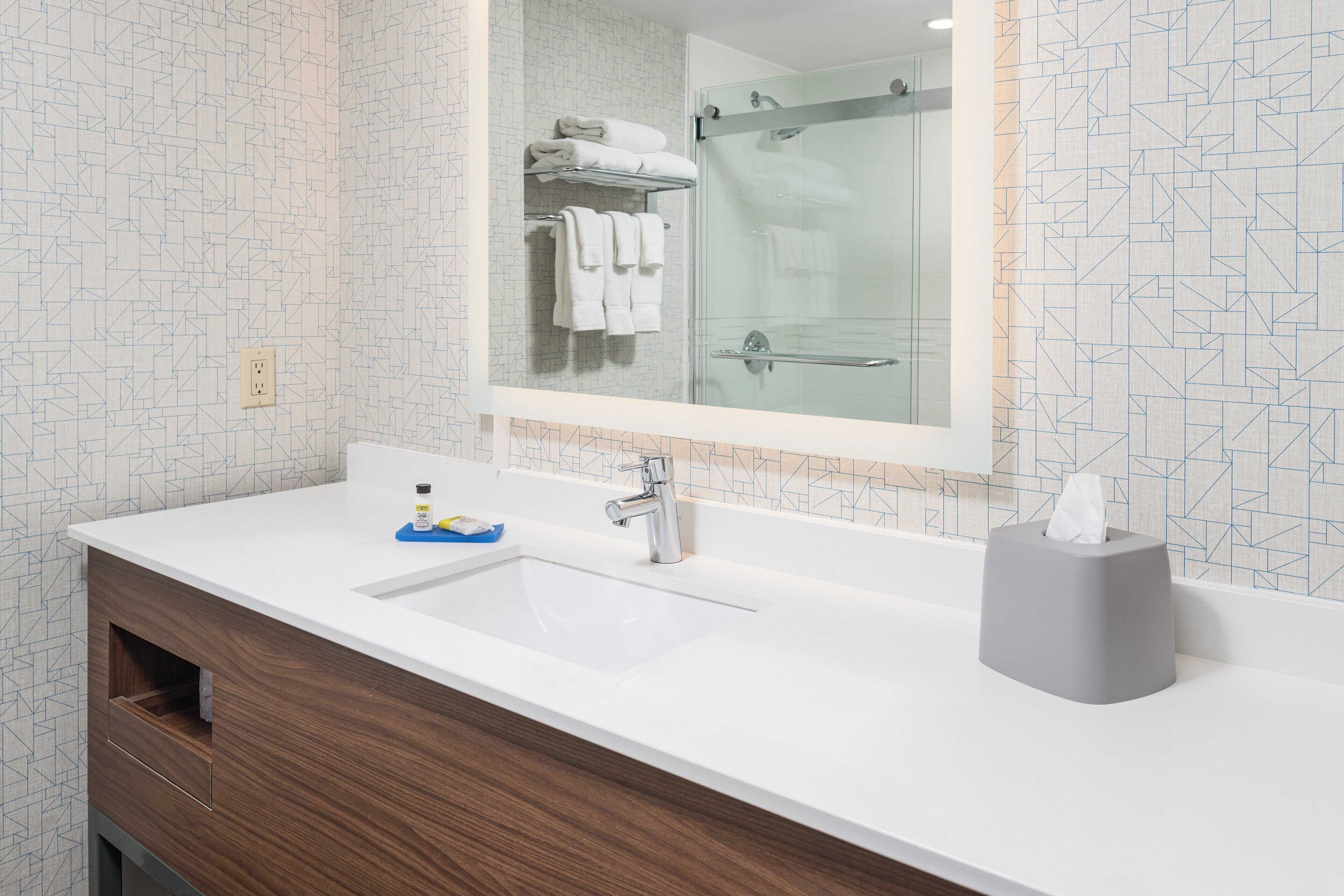 A bathroom with a white sink, a mirror, and a towel rack.