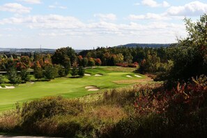 A golf course with a clear view of the green, sand bunkers, and surrounding trees. - Holiday Inn Express & Suites Milton by IHG (Milton)