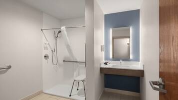 Ein modernes Badezimmer mit Duschkabine aus Glas, einer weißen Toilette und einem Waschbecken mit blauer Akzentwand.