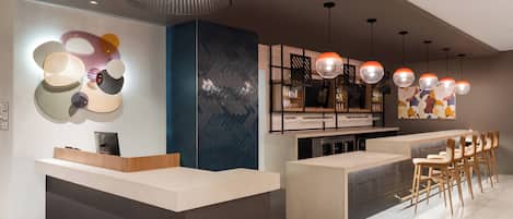 Un área de recepción moderna con mostrador, asientos y bar.
