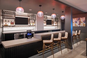 A modern bar area with a counter, stools, pendant lighting, and a neon sign. - Atwell Suites Panama City Beach Southeast by IHG (Panama City Beach)
