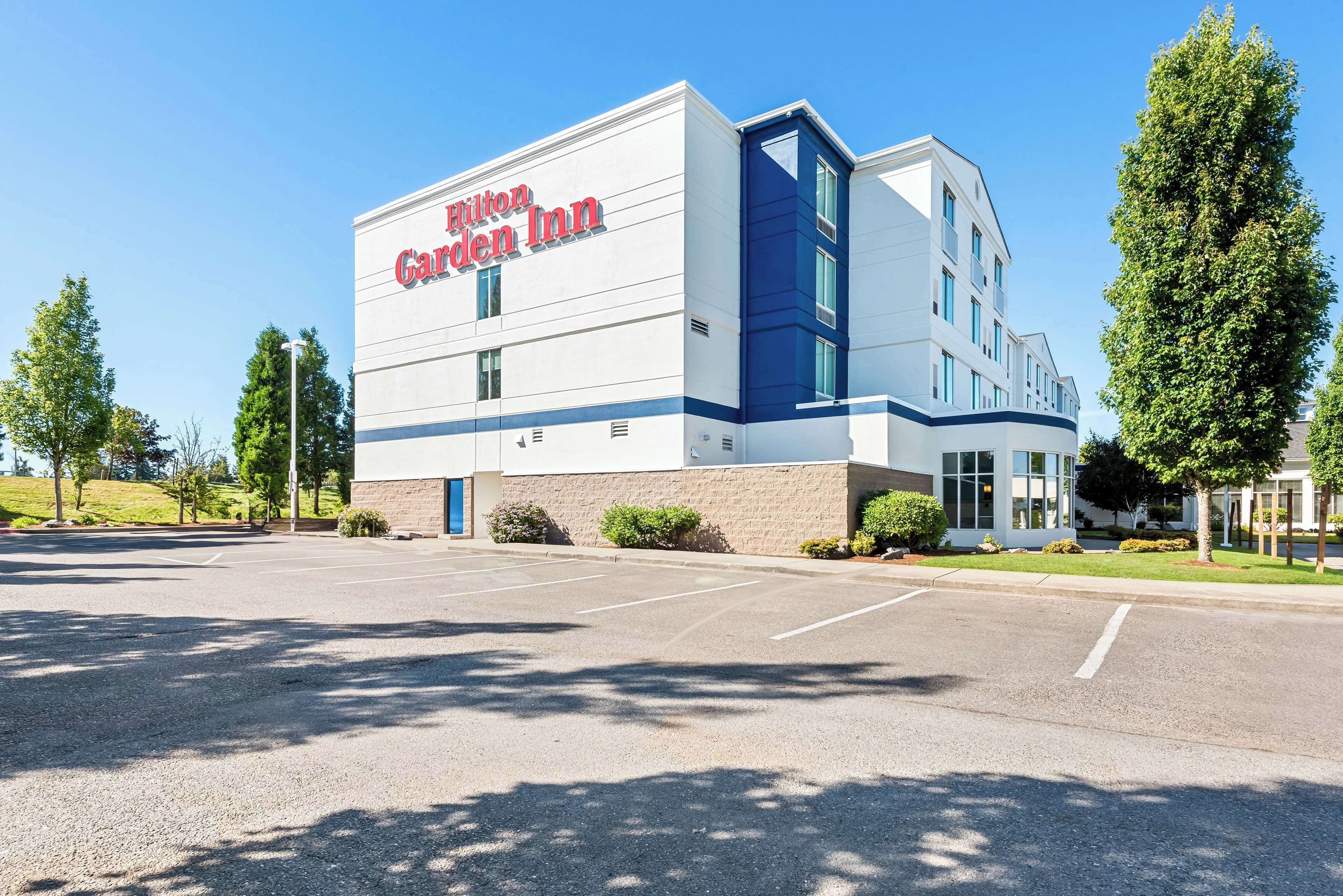 En Hilton Garden Inn bygning med en parkeringsplads foran.