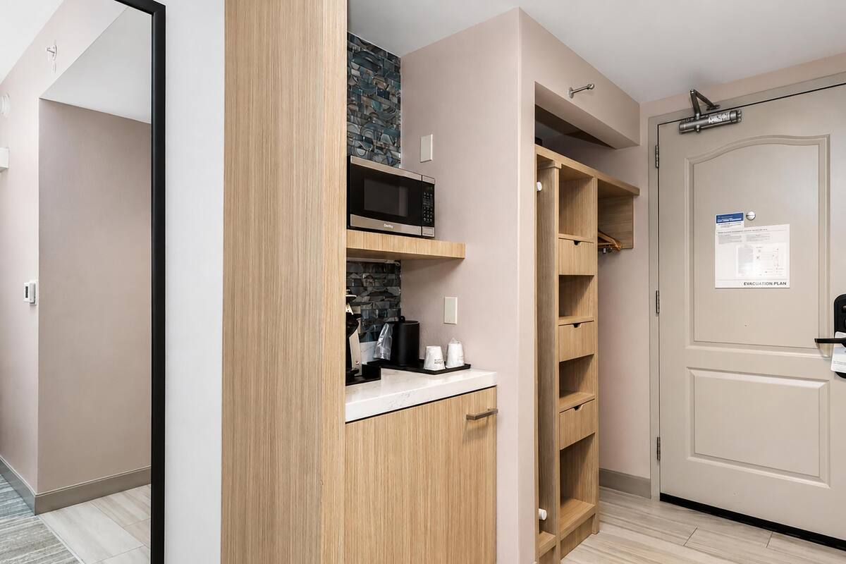 A modern kitchen with wooden cabinets, a microwave, and a countertop.