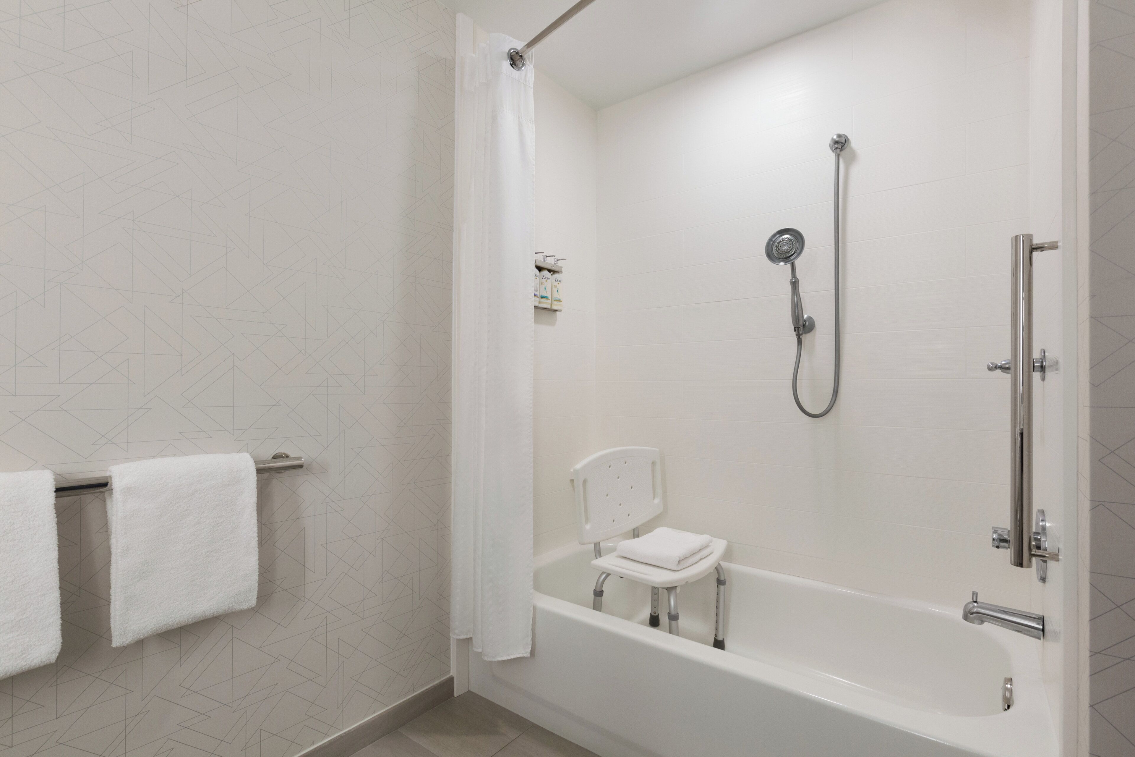 Un baño moderno con cabina de ducha, bañera blanca y asiento de ducha.