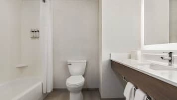 Uma casa de banho moderna com banheira, sanita e lavatório.