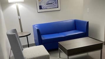 A room with a blue sofa, a grey armchair, and a small table.