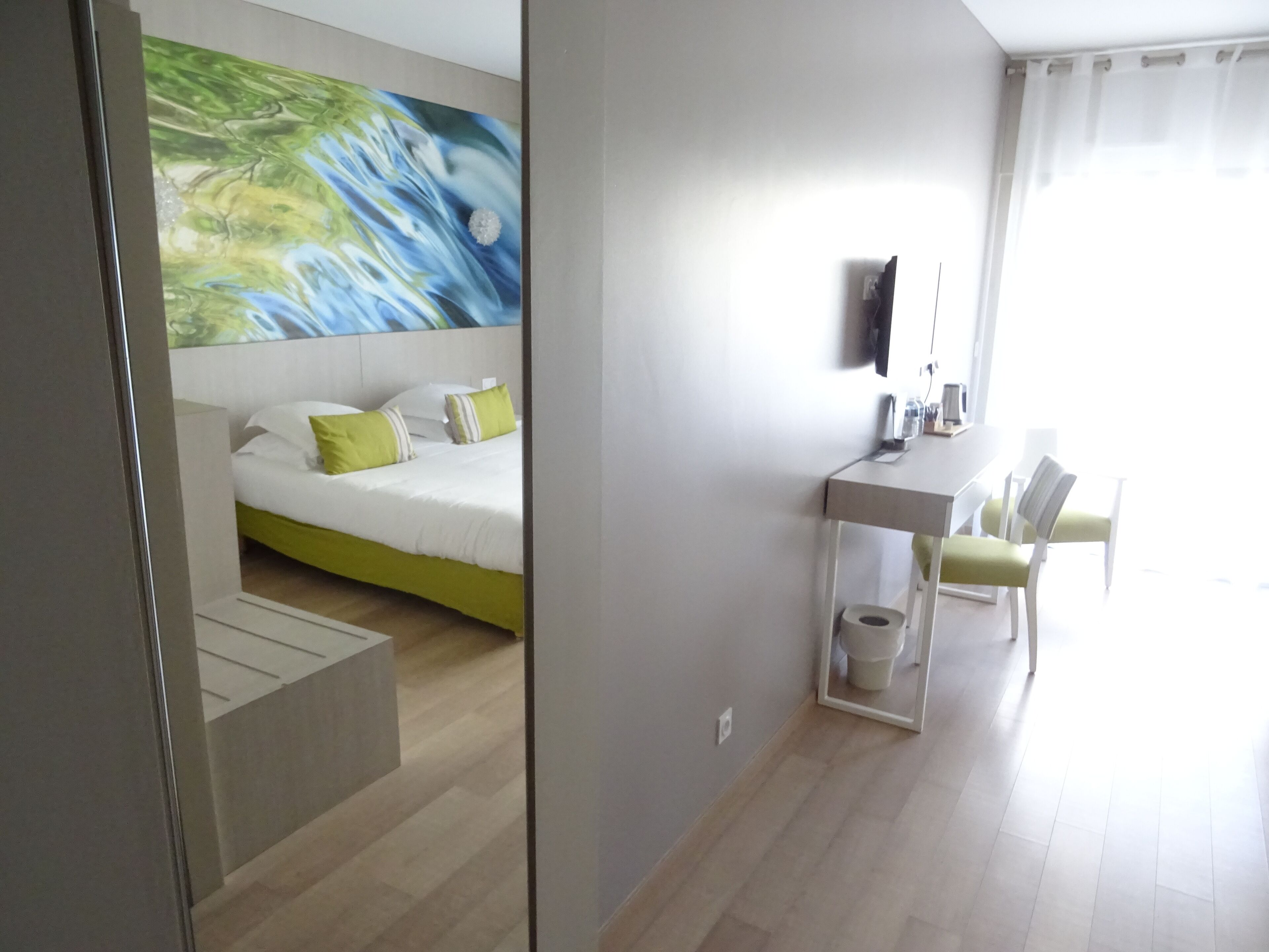 Une chambre d’hôtel moderne, équipée d’un lit, d’un bureau et d’une chaise.