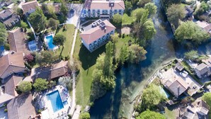 Vista aérea de una zona residencial con casas, una piscina y un río.