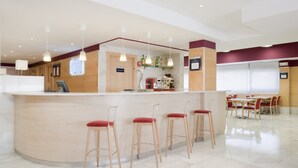A bar area with stools, a counter, and a sign indicating the bar's name. - Holiday Inn Express Madrid-Alcobendas by IHG (Alcobendas)
