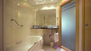 Une salle de bain moderne avec une baignoire, une douche à l’italienne et un meuble-lavabo avec un miroir.