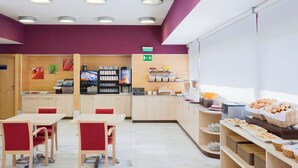 A modern cafe with seating, a coffee machine, and a variety of food items. - Holiday Inn Express Madrid-Alcobendas by IHG (Alcobendas)