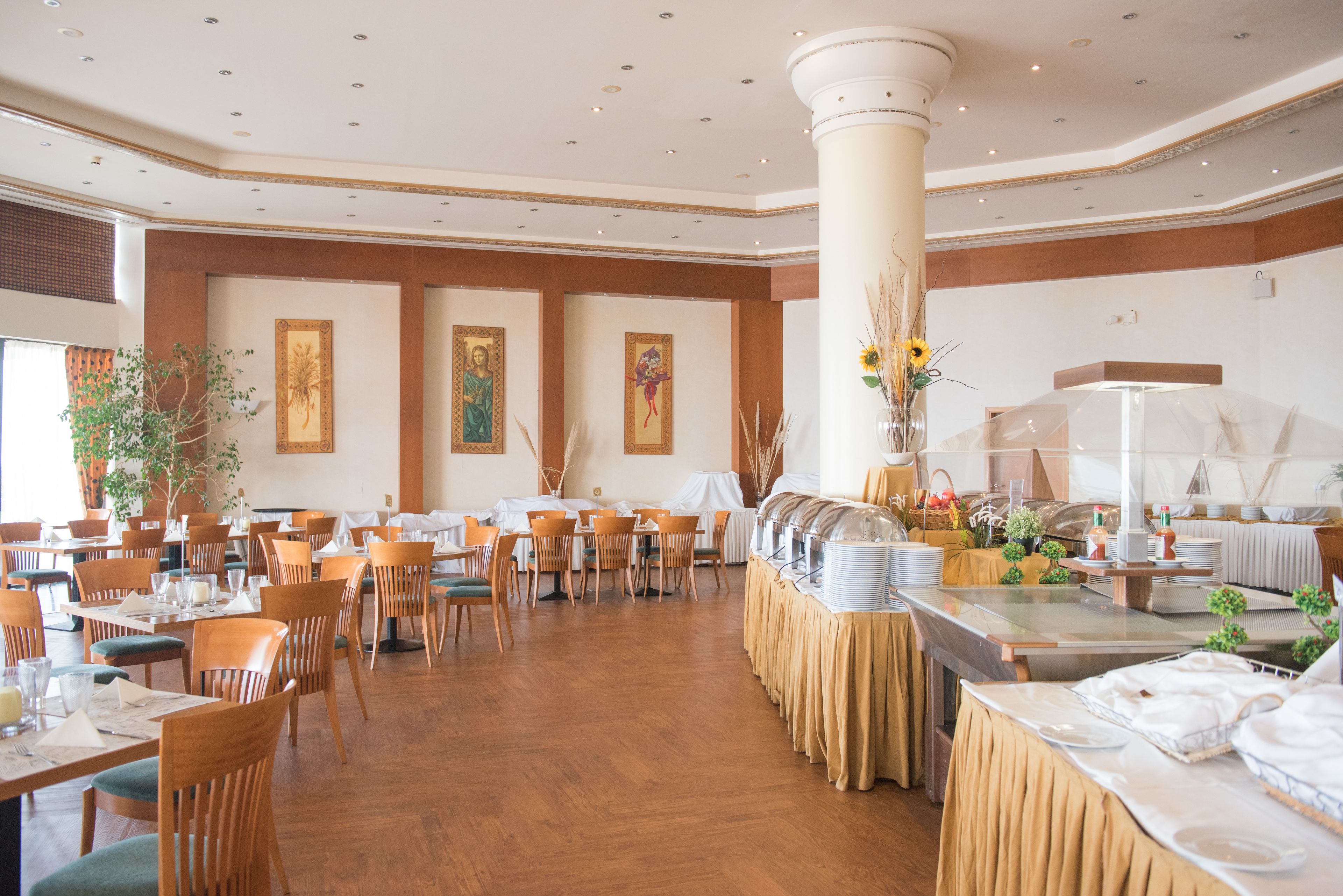 Un comedor amplio con varias mesas y sillas, una barra libre y decoración en las paredes.