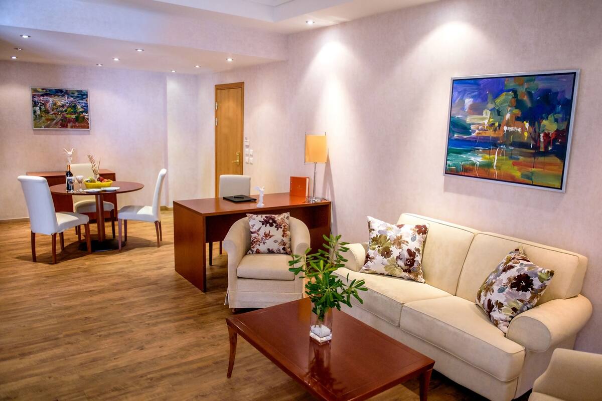 A modern living room with a sofa, coffee table, and dining area.