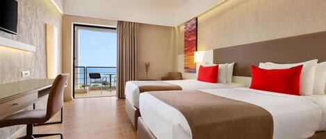 A hotel room with a large bed, a desk, and a chair. There is a balcony with a view of the sky.