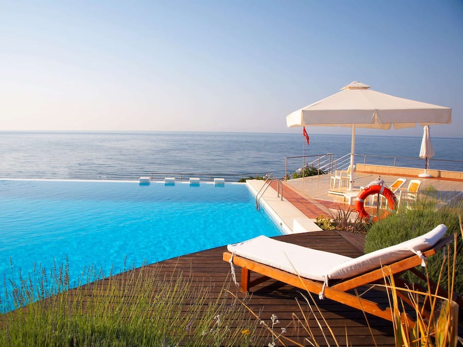 En säsongsöppen utomhuspool, parasoller och solstolar