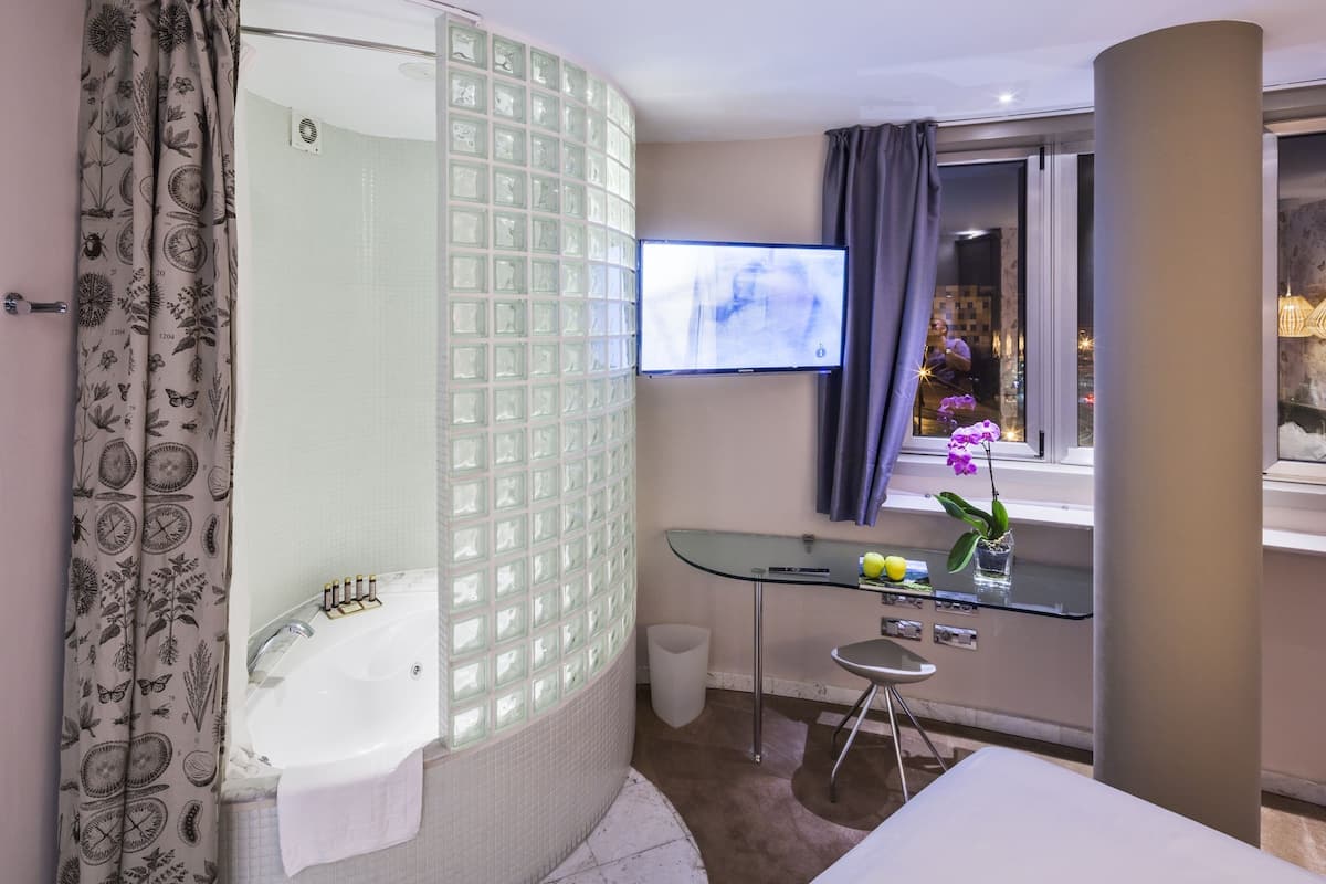 Une salle de bain moderne avec une douche à parois de verre, un lavabo blanc et un meuble-lavabo en verre.