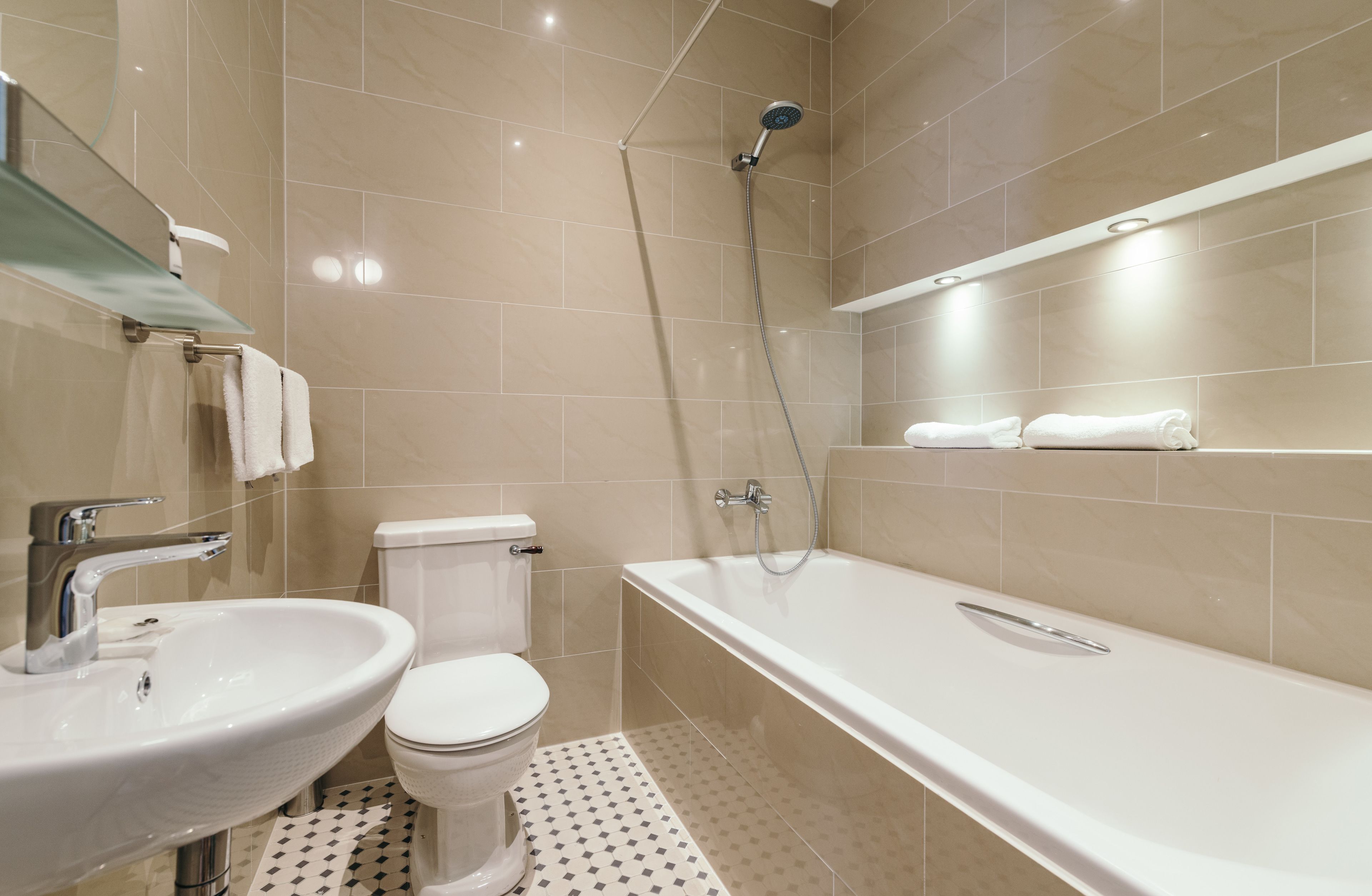 A modern bathroom with a sink, toilet, and bathtub.