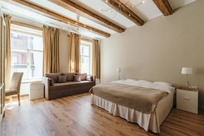 Ein Schlafzimmer mit Bett, Sofa, Sessel und Nachttisch.