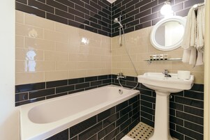 Ein Badezimmer mit Badewanne, Waschbecken und Spiegel.