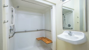 A bathroom with a shower, grab bar, and sink. - Candlewood Suites Jefferson City by IHG (Jefferson City)