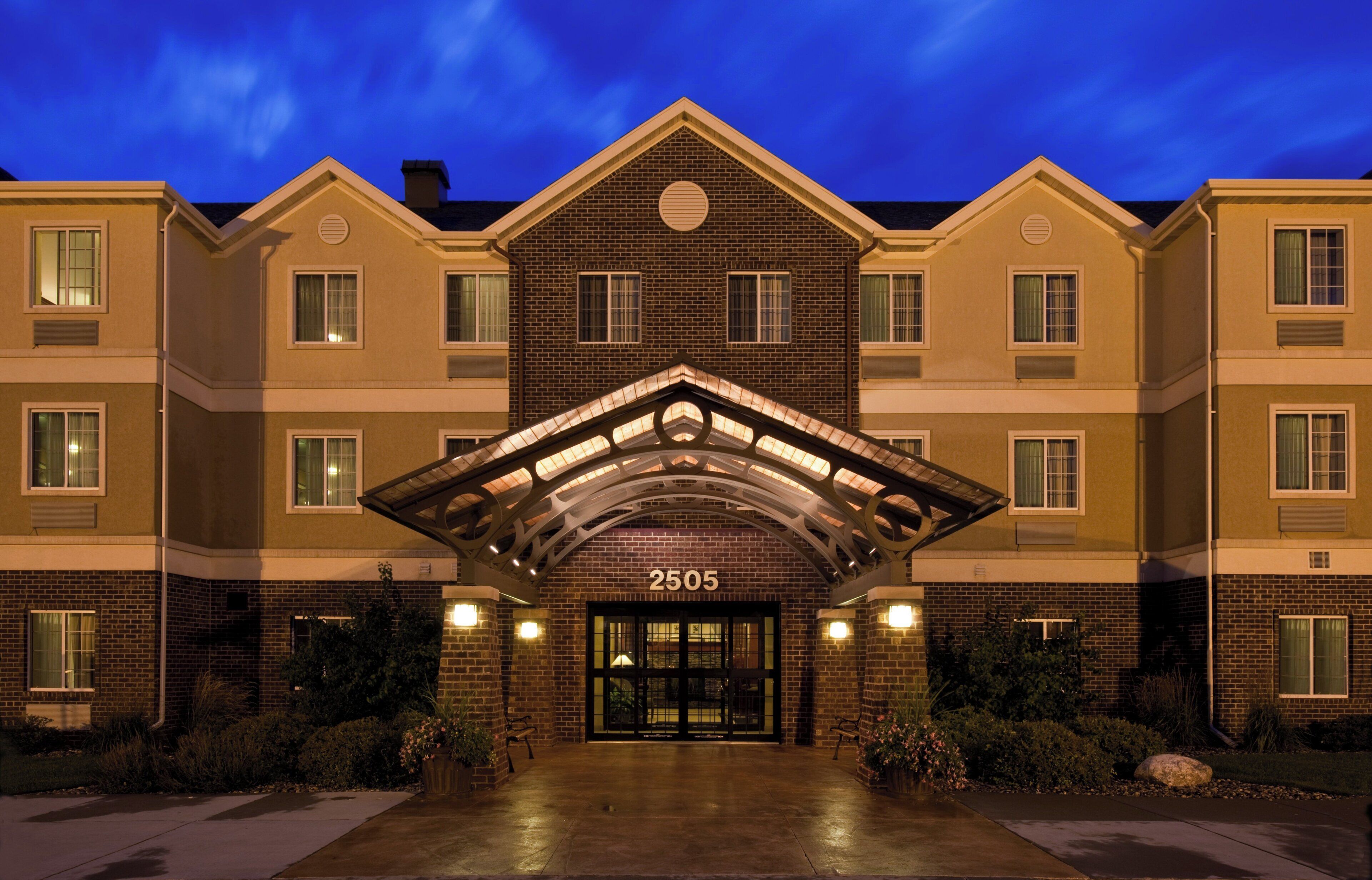 A multi-story hotel with a prominent entrance number 2505, featuring a brick facade and a symmetrical design.