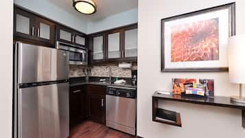 A modern kitchen with stainless steel appliances, dark wooden cabinets, and a tiled backsplash.